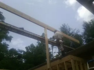 Carpenter setting a ridge beam over a new addition frame — Ice Dam Removal by Roofing Brothers in Jerico Springs