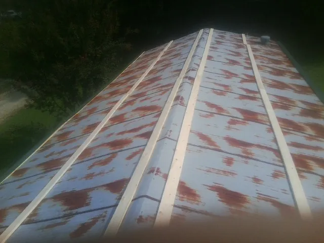 Rusted metal roof panels with new wood purlins before replacement — Storm Damage Roof Repair in Jerico Springs by Roofing Brothers