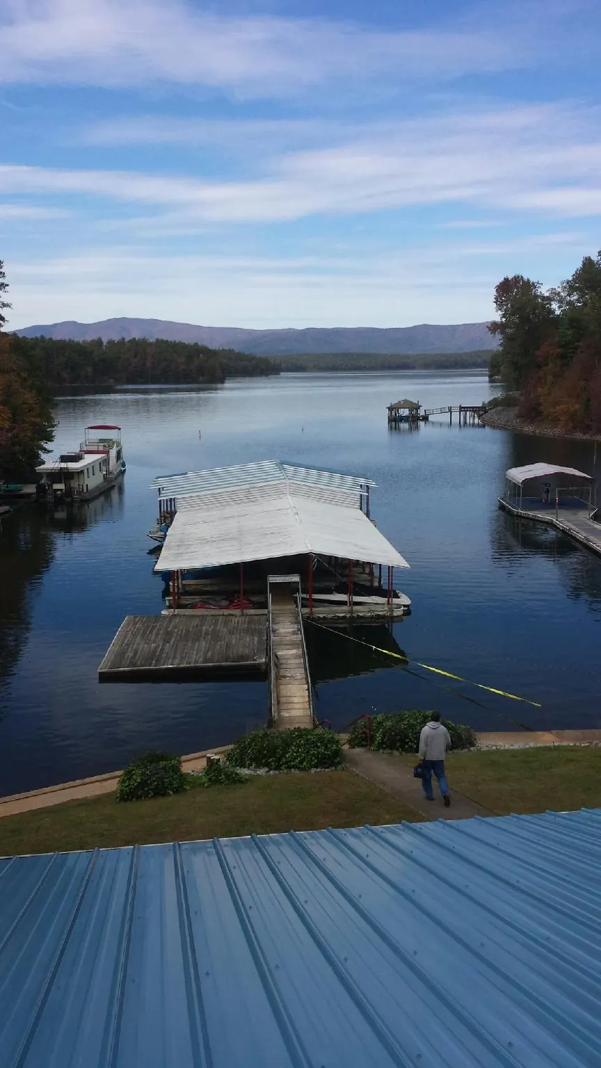 View across a lake from a newly installed blue metal roof in Jerico Springs