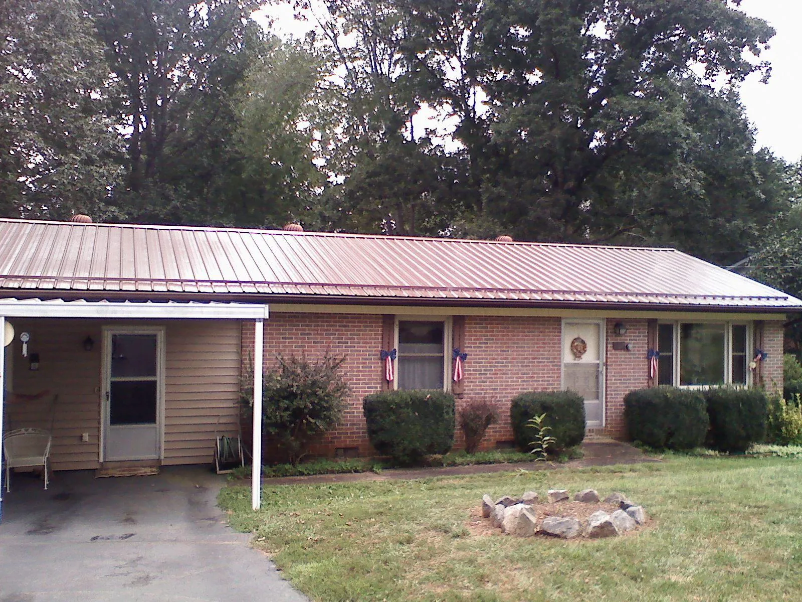 Bronze metal roof and carport on a brick ranch home — Roof Repair work by our crew in Jerico Springs